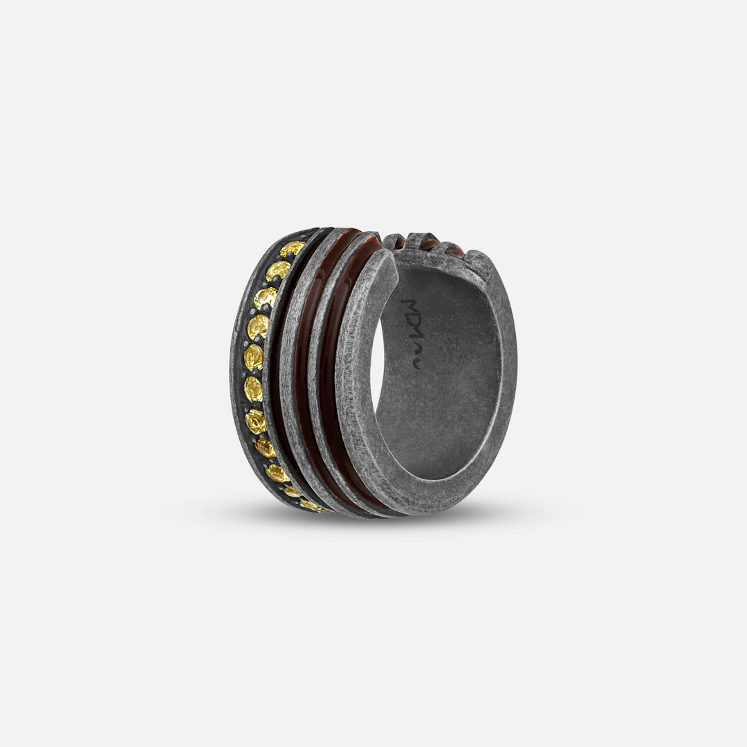 Bold ring in tarnished silver and yellow stones on a light ground.
