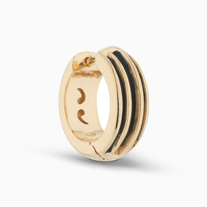 MARCO DAL MASO ACIES Huggie Earring in 18k yellow gold vermeil with contrasting black enamel stripes, featuring a polished curved design, shown in an angled product view.