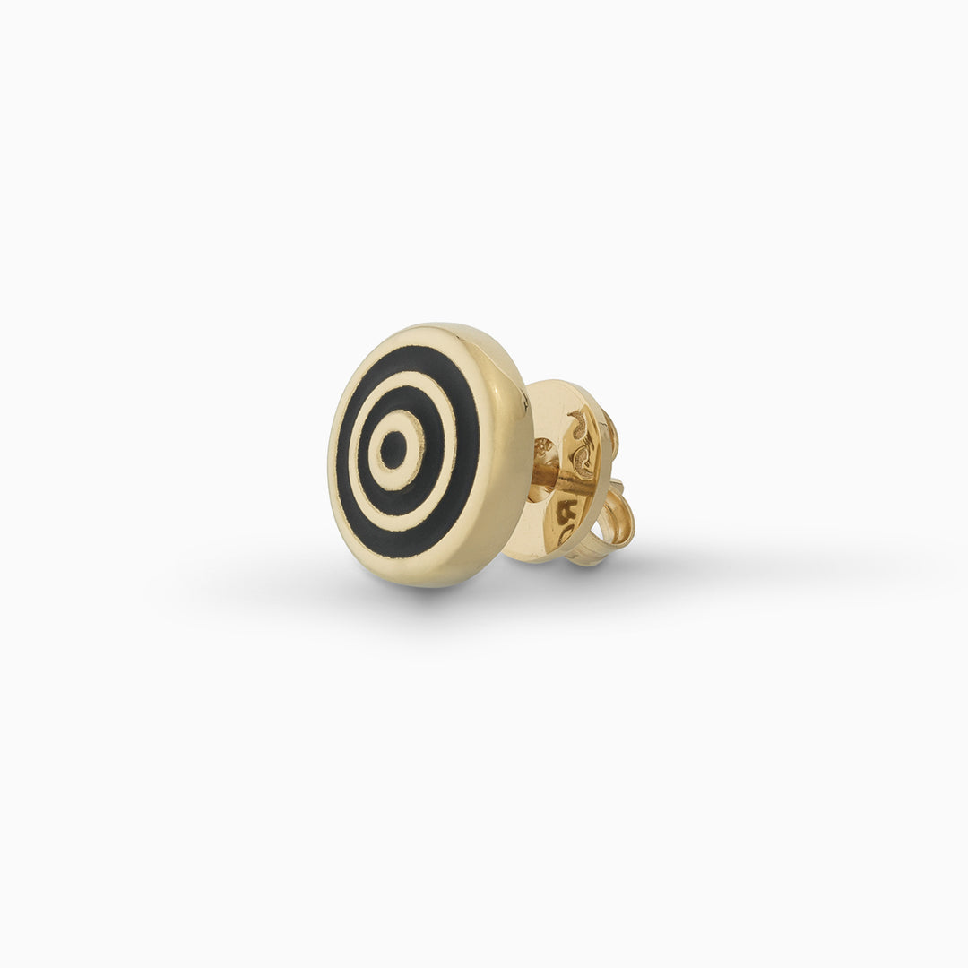 MARCO DAL MASO Acies Ipnotic Earring in yellow gold with black enamel, featuring a circular stud design with concentric gold and black rings, shown in an angled product view against a light background.