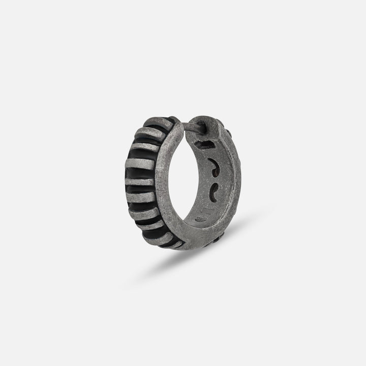 MARCO DAL MASO Acies Mini Hoop Earring in oxidized silver with black enamel detailing, featuring a ribbed hoop design, shown in an angled product view against a light background.