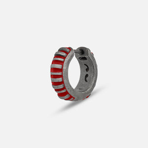 MARCO DAL MASO Acies Mini Hoop Earring in oxidized silver with vibrant red enamel stripes, featuring a ribbed hoop design, shown in an angled product view against a light background.