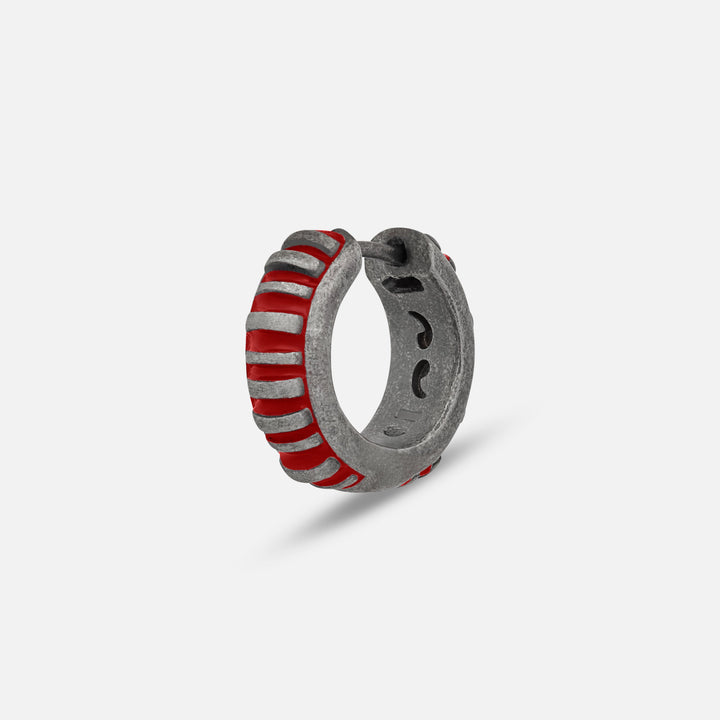 MARCO DAL MASO Acies Mini Hoop Earring in oxidized silver with vibrant red enamel stripes, featuring a ribbed hoop design, shown in an angled product view against a light background.