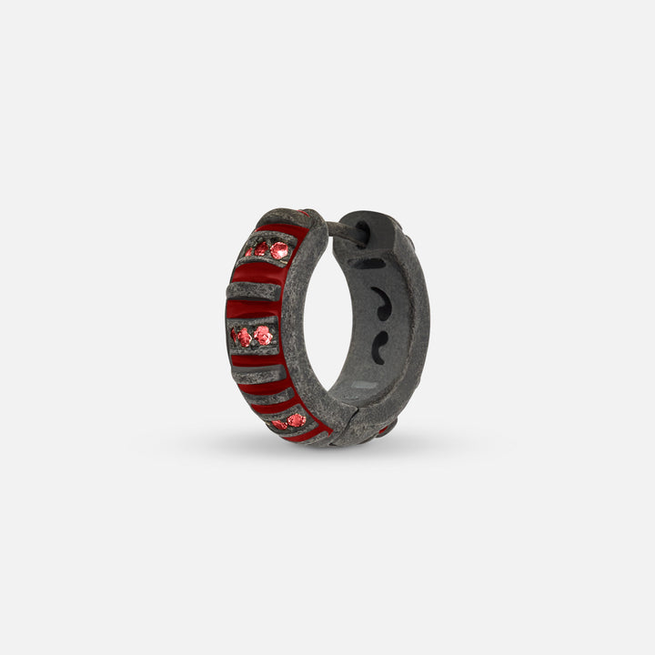 MARCO DAL MASO Acies Mini Pavé Hoop Earring in oxidized silver with red enamel and red sapphires, shown in an angled product view highlighting the gemstone accents and textured finish.