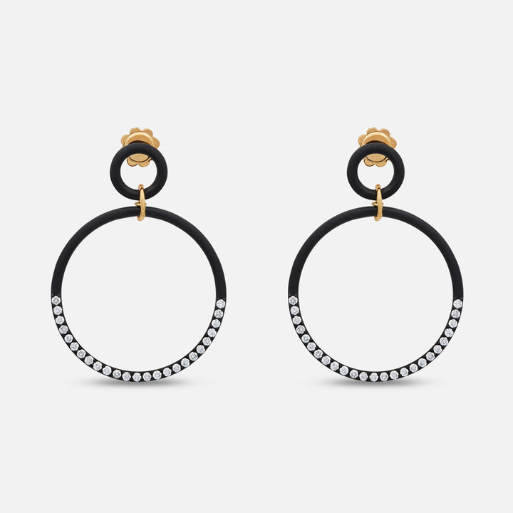 MARCO DAL MASO Eclipse Twin Orbit Earrings in black titanium, featuring double circular hoops with sparkling stone-set detailing and gold-tone connectors, displayed against a light background.