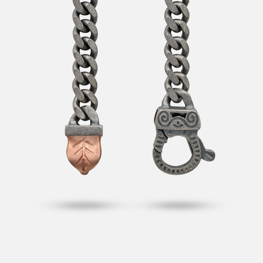 Macro view of curb chain showcasing clasp details on a light stage.