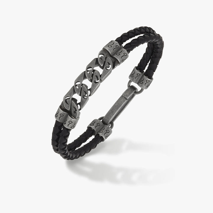 Braided bracelet in black leather and antique silver on a soft backdrop.