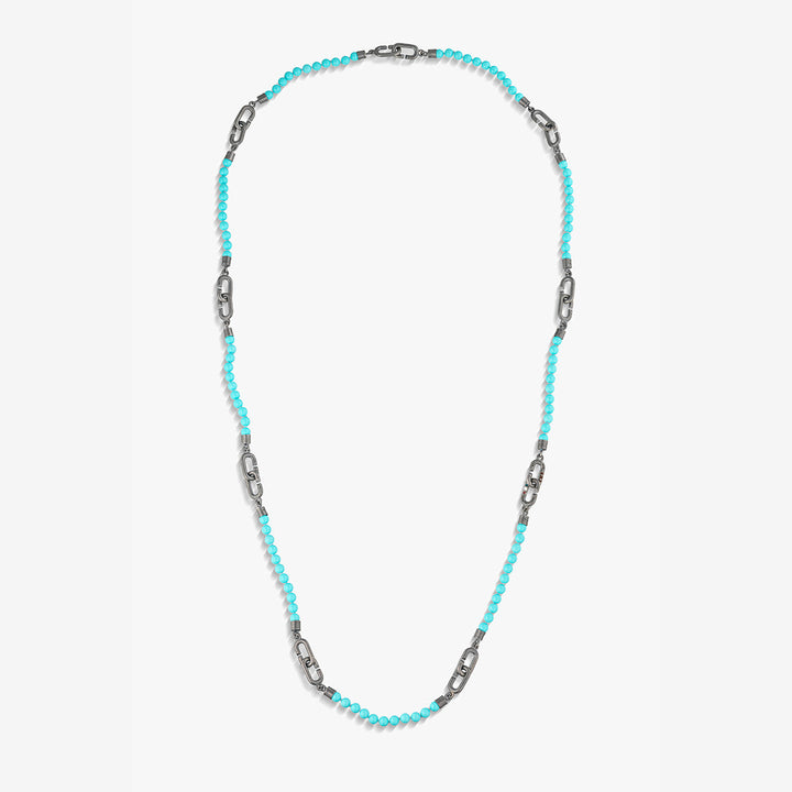 Long necklace in turquoise beads and link hardware on white backdrop.