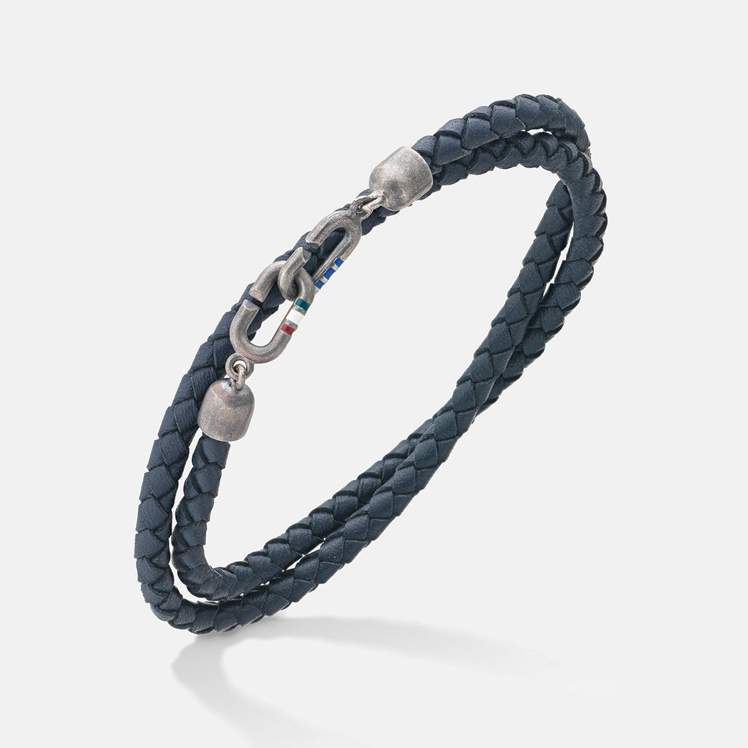 Double-wrap bracelet in dark blue leather and metal on a pale floor.