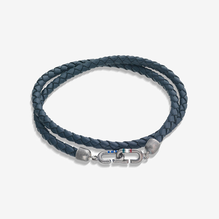 Coiled cuff in braided cord and silver hardware on a neutral surface.