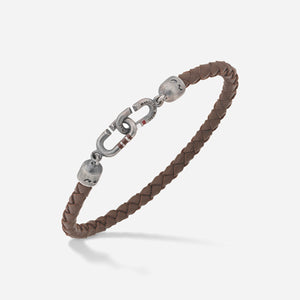 Woven bracelet in brown leather and antique silver on a soft backdrop.