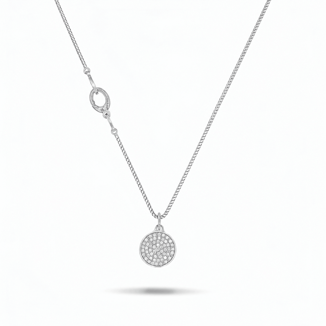 A silver chain necklace featuring a circular pavé pendant and a matching oval clasp, displayed on a clean white background with a soft shadow underneath.
