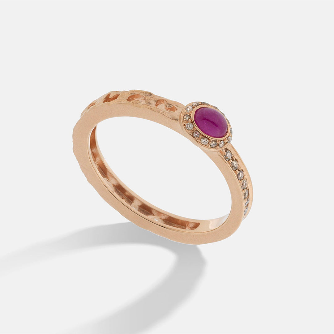MARCO DAL MASO Orion Oval Gemstone Ring in rose gold, featuring an oval pink sapphire surrounded by champagne diamonds and a textured band, shown in an angled product view.
