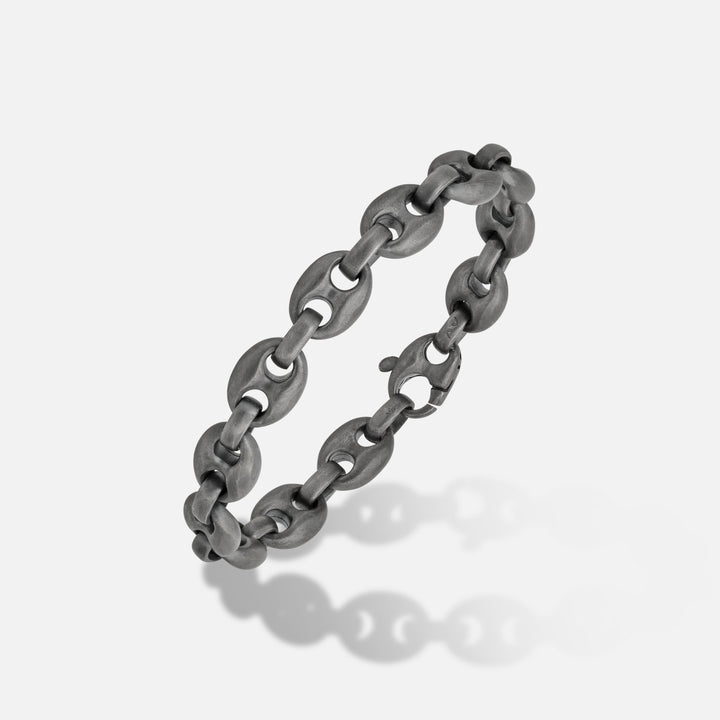 Chunky chain in dark sterling silver on a minimalist backdrop.