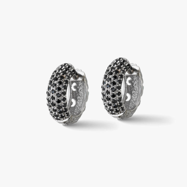 Paired view of crystal earrings displaying dual setting on clean floor.