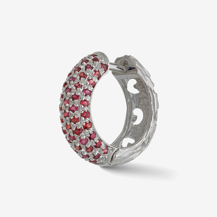 MARCO DAL MASO Warrior Pavé Hoop Earring in white gold with red sapphires, featuring a textured hoop design and pavé-set gemstones, shown in an angled product view against a light background.