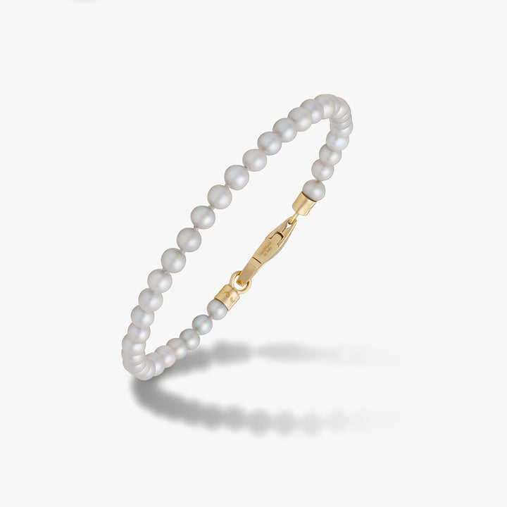 White pearl bracelet with a gold-tone clasp.