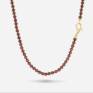 MARCO DAL MASO XOK Wave Mini Beaded Necklace featuring chocolate pearls and a gold-tone clasp, displayed against a light background.