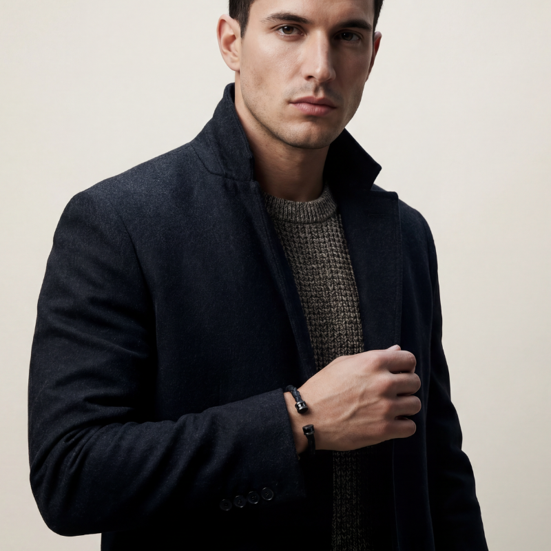 Lifestyle shot of Acies Collection cuff accessorizing a dark tailored coat and textured knitwear.