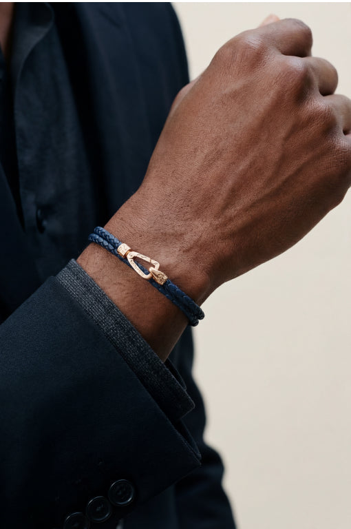 Close-up of a dark blue braided bracelet with a gold-tone clasp.