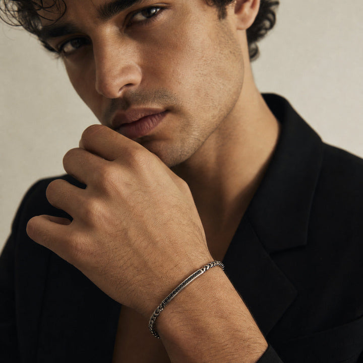 Man wearing a bracelet with a neutral background