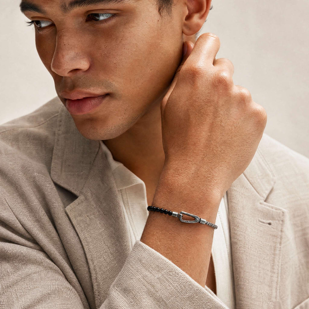 Male model wearing the Ulysses Mini Beads Chain Bracelet in oxidized silver with onyx beads.