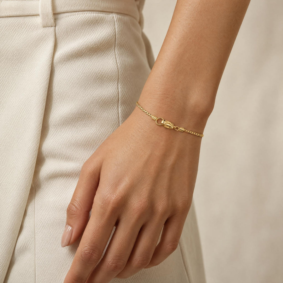 Model wearing the Ulysses Slim Tubular Bracelet in polished yellow gold vermeil, featuring a delicate chain and refined clasp detail.