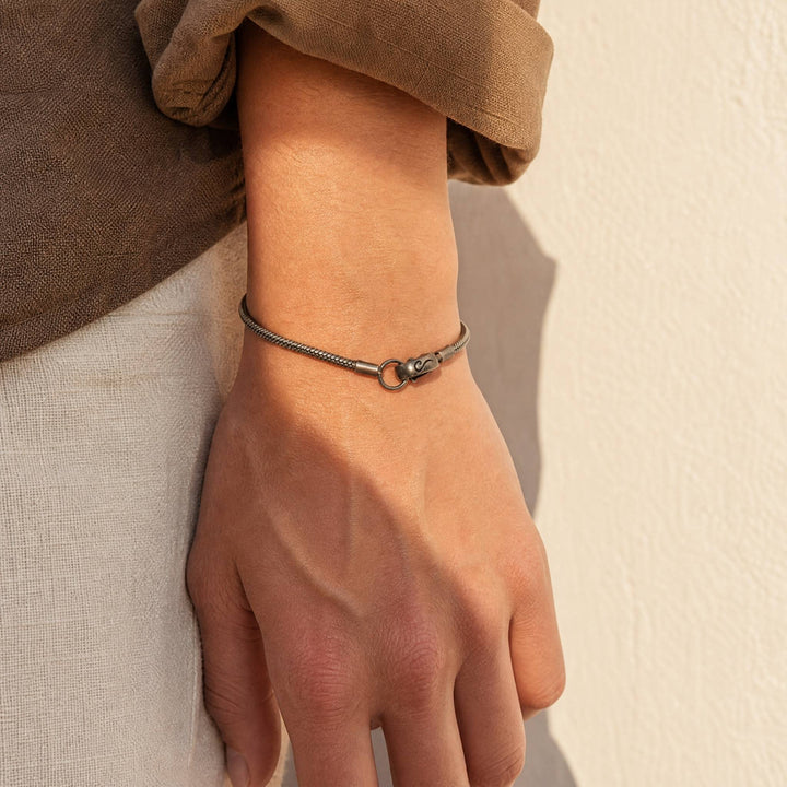 Ulysses Slimline Bracelet in oxidized silver worn on the wrist by a model.